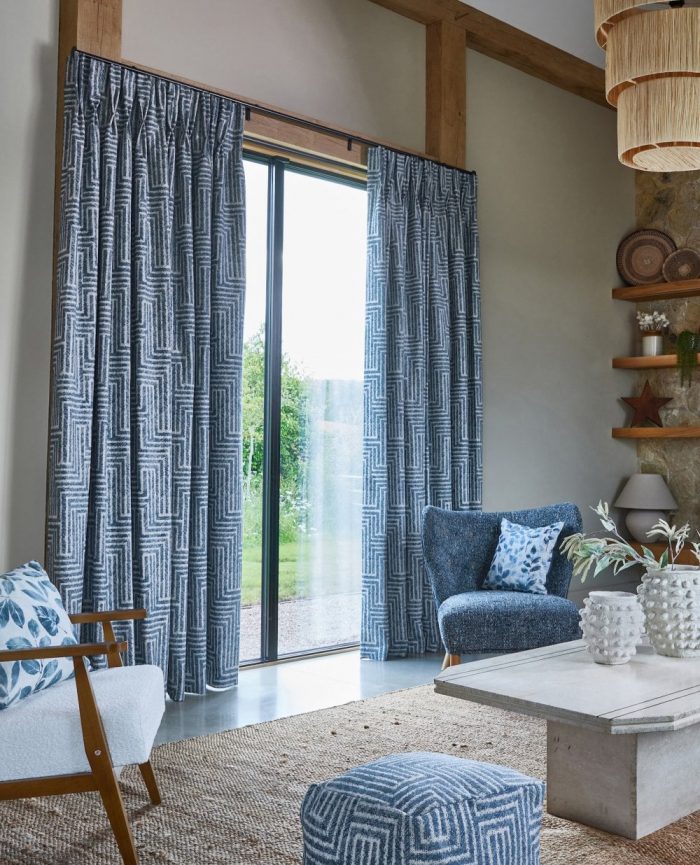 Blue and white geometric curtains in a living room with a matching chair