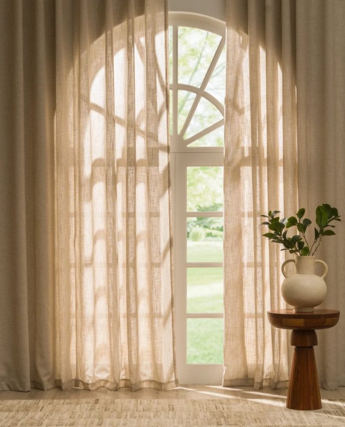 Beige voile curtains hanging in front of a large window