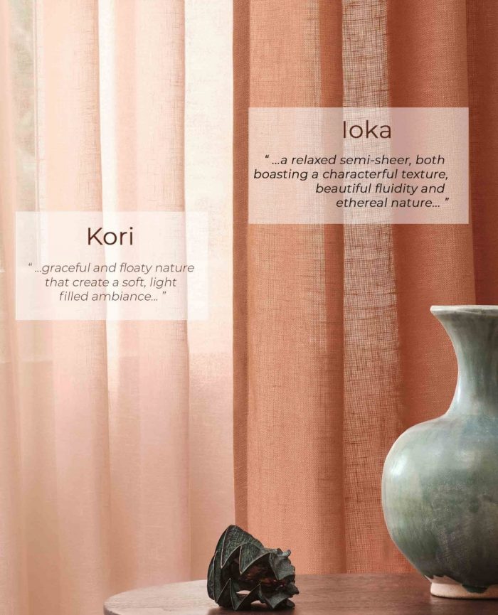 Coral coloured linen voile curtains hanging with a table and vase next to them